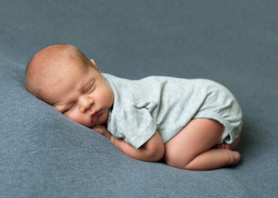 baby boy curled up asleep in photo session
