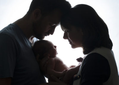 backlit shot of mummy and daddy with their newborn baby girl