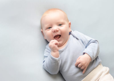 cute baby smiling in his newborn session in Farnham