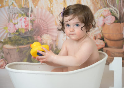 Little girl in splash bath after her cake smash session